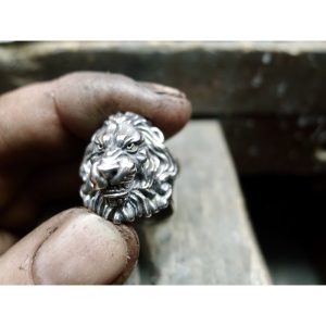 Photographed in the jewellers hands - This silver lions head ring with flowing mane is not just a piece of Irish jewelry - it is a symbol of courage, bravery, and resilience. Whether you're looking for a unique accessory to wear every day or a special gif